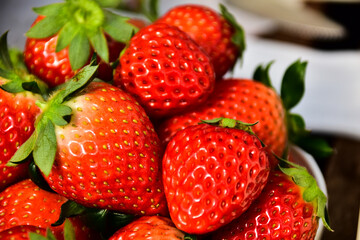 皿に山盛りの赤い完熟苺、いちご狩り