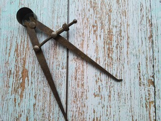 Antique calipers, on a wooden table, top view with copy space.