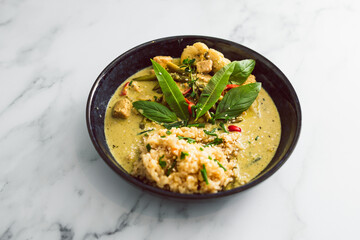 vegan green curry with tofu bell pepper and cauliflower served with brown rice, healthy plant-based food