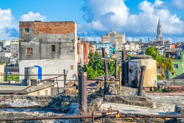 HAVANA, CUBA,  Run-down rooftops compared famous landmarks. In the distance, the Masonic building and the Reina Church. 