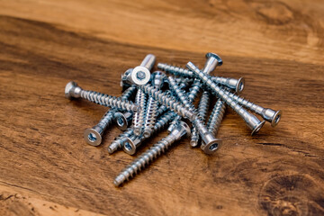 Close up of hex bolts screw for furniture assembly on wooden background.
