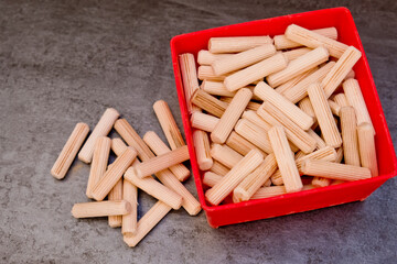 View of a grouping of wooden dowels on grey background. Close-up.