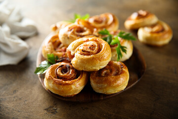 Homemade puff pastry swirls with bacon and tomato