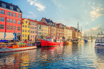 An old red and white fishing boat stands among other ships and yachts near the old small...