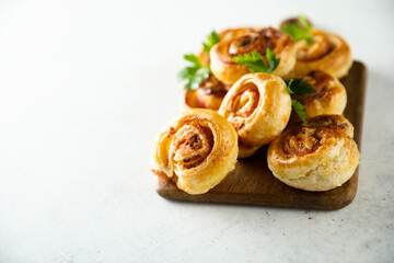 Homemade puff pastry swirls with bacon and tomato