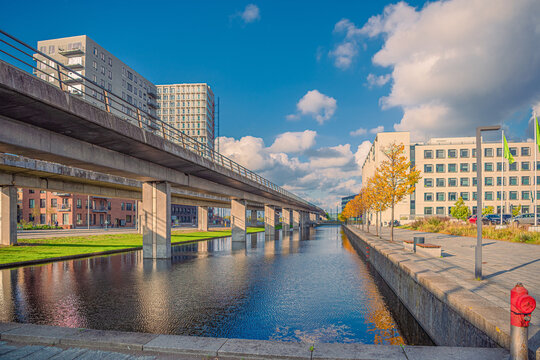 Canal with water on &Oslash;restad boulevard in the city area &Oslash;restad. On the bridge, metro subway line M1. Copenhagen , Denmark