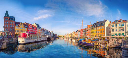 Fototapeta na wymiar Panorama of the Nyhavn canal with boats, ships and many small colorful houses. Copenhagen, Denmark