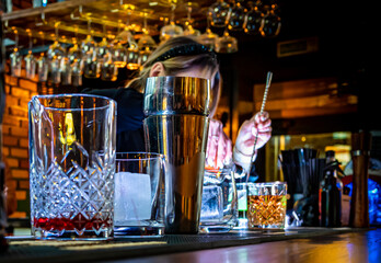 bartender hand making cocktail in glass on bar counter