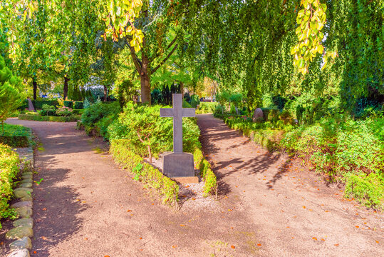 Stone headstone with a cross at the crossroads in Garrison Cemetery. Copenhagen, Denmark