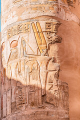 hieroglyphs and drawings of pharaohs carved in sandstone column in Karnak temple in Luxor. Egyptian heritage and history concept