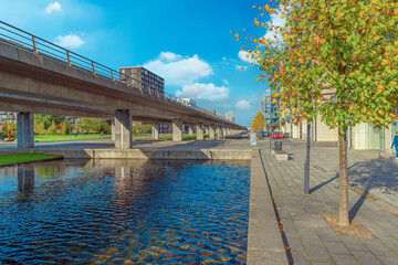 Water canal, metro line and pedestrian street near Ørestad boulevard in Copenhagen, Denmark