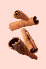 cinnamon sticks fly on a beige background, close-up