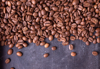 coffee beans are scattered over a gray background, food background, horizontal orientation