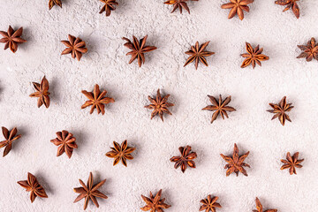 star anise scattered on white plaster, pattern