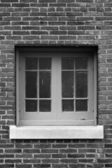 old window on a brick wall in black and white