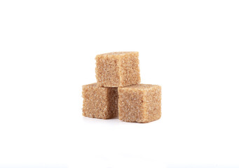 Three cubes of cane sugar on a white background.