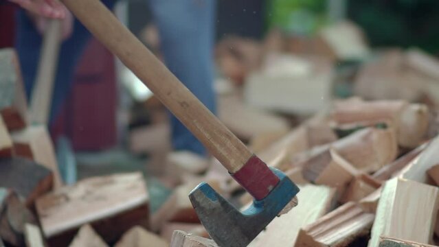Detail of two flying pieces of wood on log with sawdust while stong man is chopping firewood with vintage axe, slow motion