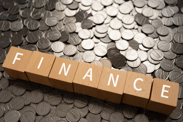 ファイナンスのイメージ｜「FINANCE」と書かれた積み木とコイン