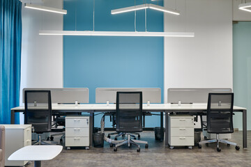 Empty office desk with vacant workplaces in blue interior design