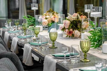 Decoration with green glass, flowers and candles for wedding furshet
