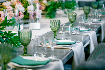 Decoration with green glass, flowers and candles for wedding celebration