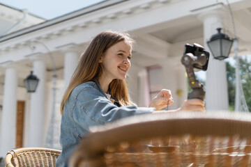 Uses a phone video call blogger female freelancer working in a summer cafe