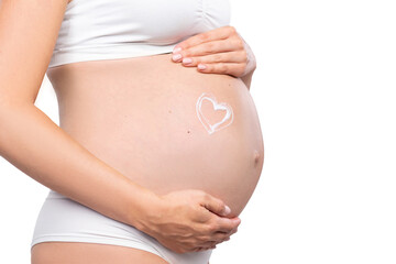 Young pregnant woman in swimsuit. Girl expecting a baby and touching her belly isolated on white background. Close-up image.