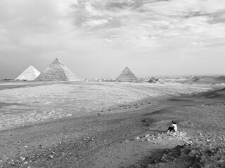 A traveler looks at the Giza pyramid complex near Cairo, Egypt. Black and white photo