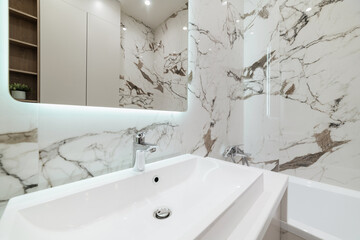 bright bathroom interior with washbasin and mirror