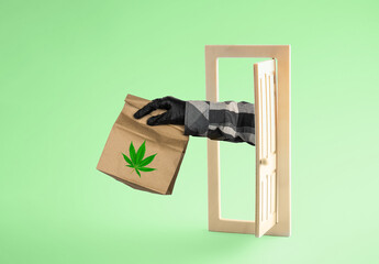 Concept of marijuana delivery. Courier's hand with  package of medical marijuana is stretched out...