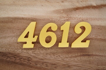 Golden Arabic numerals on a real brown and white wooden floor number 4612