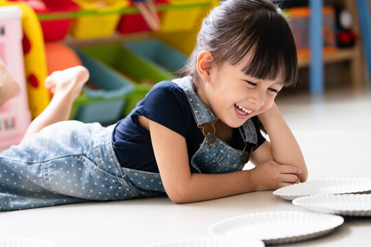 Adorable 3 years old is smiling with fully happiness moment while she playing indoor at home, concept of learning through playing activity for kid development. 