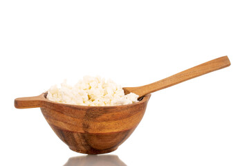 Fototapeta na wymiar Fragrant tasty cottage cheese in a wooden cup with a wooden spoon, macro, isolated on a white background.