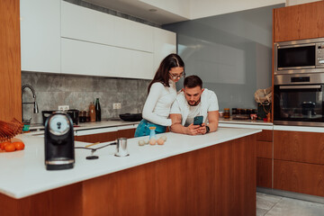 Young happy couple using two phones share social media news at home, smiling husband and wife...