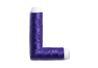 Letter of L from thread spools, isolated on white background. Alphabet concept.