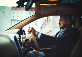 Wherever you go, arrive in style. Shot of a mature businessman driving a stylish car.
