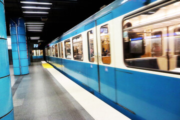 Fototapeta premium Munich, train in motion departing from the subway platform of a city station