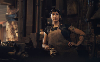 Obraz na płótnie Canvas Watch me make magic with metal. Portrait of a confident young woman working at a foundry.