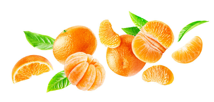 Group of flying ripe mandarins whole and peeled with leaves isolated on a white background.