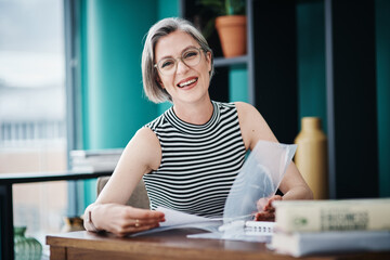 You have what it takes to succeed. Shot of of a mature businesswoman working on paperwork in her office.