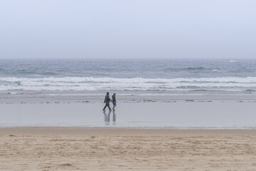 Couple walking on a rainy beach