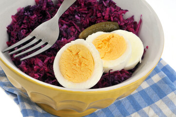 Repas diététique servi dans un bol de chou rouge avec des oeufs durs et une fourchette