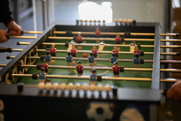 a group of young people playing table football, close-up. people's play table football in a game...