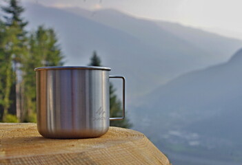 Steel cup on wood in the mountains