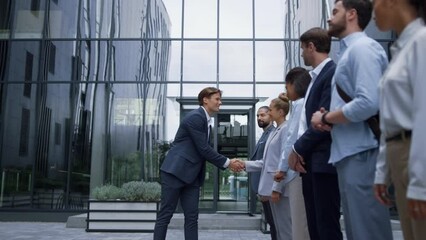 Thankful leader shaking hands at office building. Corporate lifestyle concept.