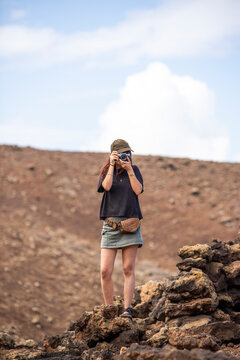 View of a woman taking photos at Timanfaya National Park, Lanzarote, Canary Islands, Spain.