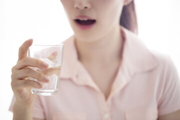 Close up of young woman drinking glass of water