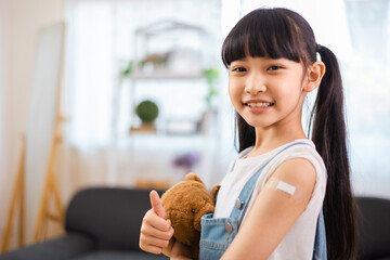 Young asian doctor wearing gloves and isolation  is making a COVID-19 vaccination in the shoulder...