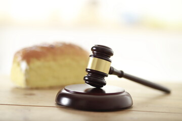Gavel with bread on wooden table