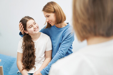 Mother and daughter having appointment with doctor in clinic